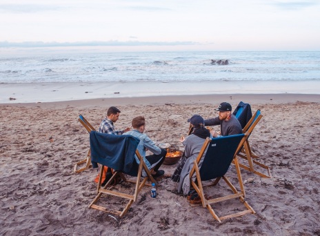 Τέσσερις φίλοι κάθονται σε καρέκλες στην παραλία