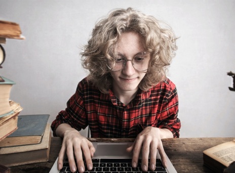 Γυναίκα με γυαλιά πληκτρολογεί σε laptop