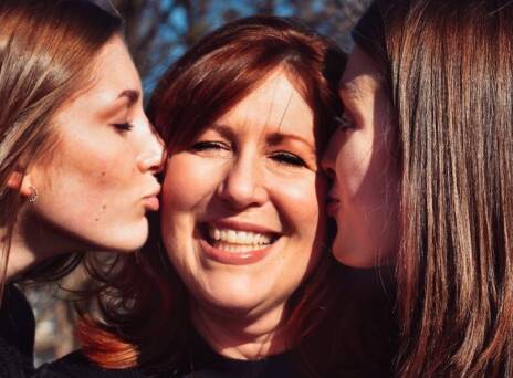 Δύο κόρες φιλάνε τη μητέρα τους στο μάγουλο