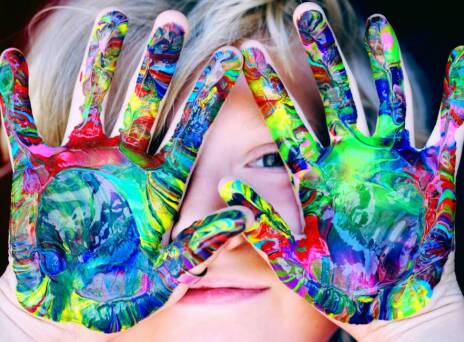 Μικρό παιδί που έχει λερώσει τα χέρια του με χρώμα