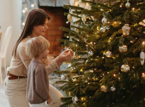Μαμά και παιδί στολίζουν το χριστουγεννιάτικο δέντρο