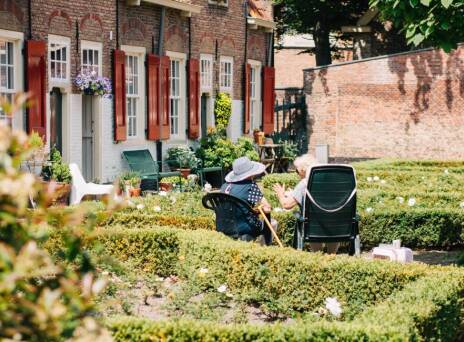 Δύο ηλικιωμένες κυρίες κάθονται σε καρέκλες στον κήπο