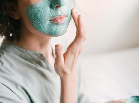 Κοπέλα απλώνει μάσκα ομορφιάς στο πρόσωπό της