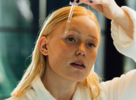 Κοπέλα που βάζει σέρουμ στο πρόσωπό της