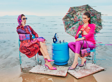 Γυναίκες με χρωματιστά ρούχα καθισμένες σε καρέκλες σε παραλία