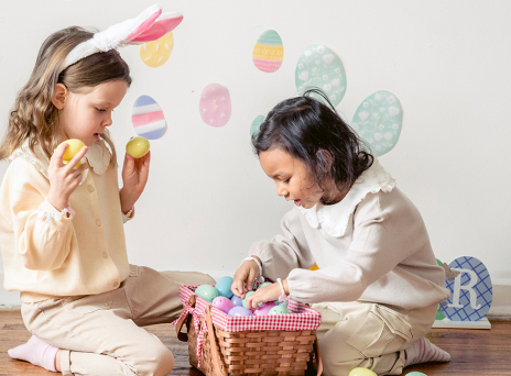Δύο μικρά κορίτσια παίζουν με πασχαλινά αυγά