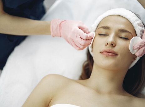 Γυναίκα ξαπλωμένη με κλειστά μάτια, δέχεται καθαρισμό προσώπου