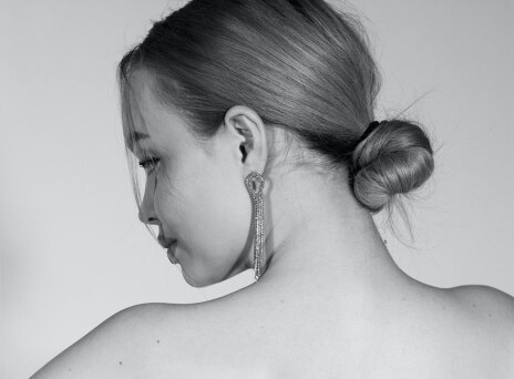 Ασπρόμαυρη φωτογραφία κοπέλας με πιασμένα μαλλιά σε χαμηλό κότσο