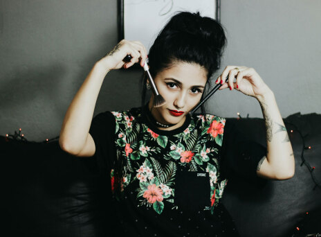 Γυναίκα κρατάει πινέλα δίπλα στα μάγουλά της