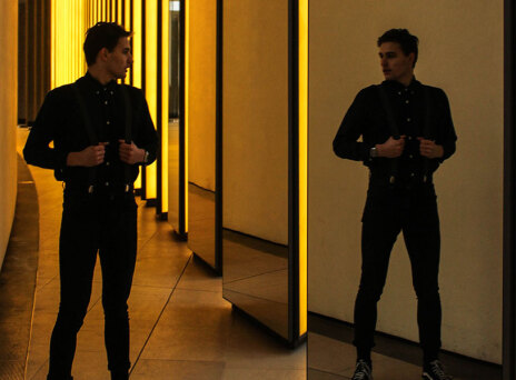 Άντρας ντυμένος στα μαύρα, που κοιτιέται στον καθρέφτη