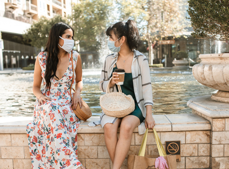 Δύο φίλες συζητούν φορώντας μάσκα για τον κορωνοιο