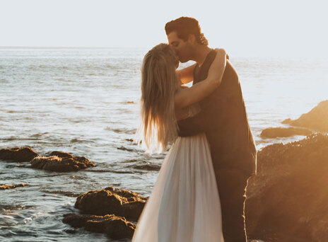 Ζευγάρι φιλιέται με φόντο το ηλιοβασίλεμα