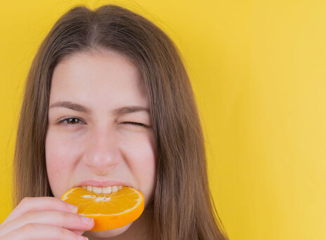 Κοπέλα δαγκώνει πορτοκάλι
