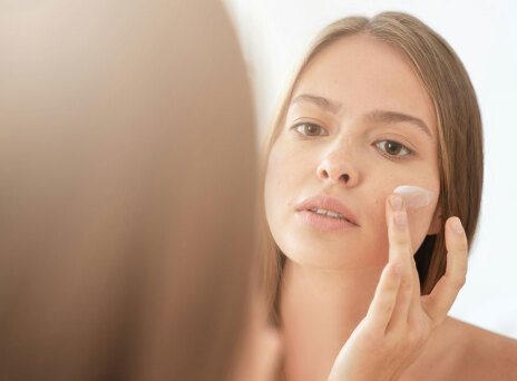 Γυναίκα βάζει κρέμα στο πρόσωπο