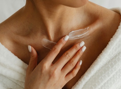 κοπέλα που απλώνει κρέμα στο σώμα 