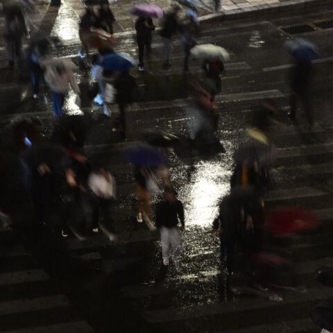 Άνθρωποι περπατούν σε δρόμο κατά την διάρκεια βροχόπτωσης