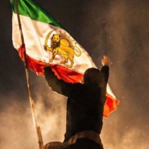 Διαδηλωτής στο Ιράν με τη σημαία του παλιού καθεστώτος