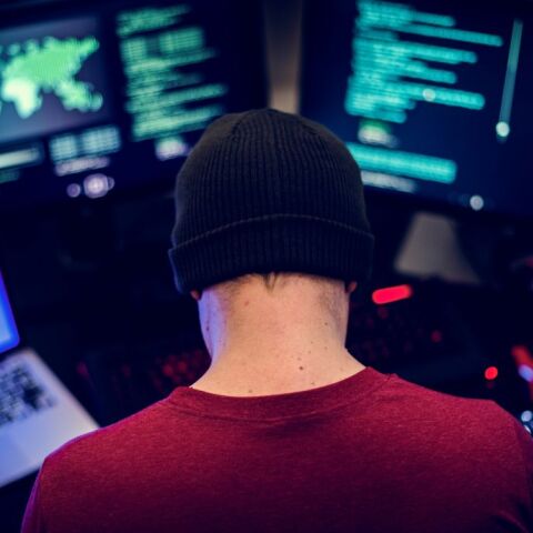 Χάκερ μπροστά από οθόνες υπολογιστών