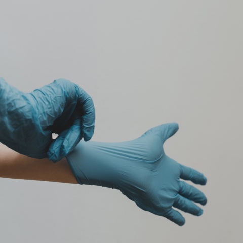 Χειρουργός βάζει τα γάντια του και ετοιμάζεται για επέμβαση