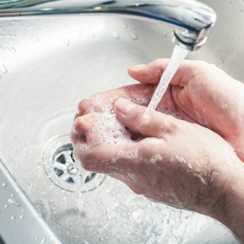 Άτομο που πλένει τα χέρια του κάτω από τη βρύση