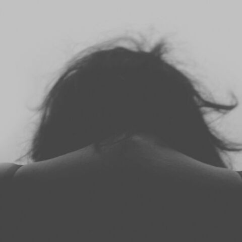 Γυναίκα με σκυμμένο κεφάλι υποδηλώνοντας πως έχει δεχτεί επίθεση