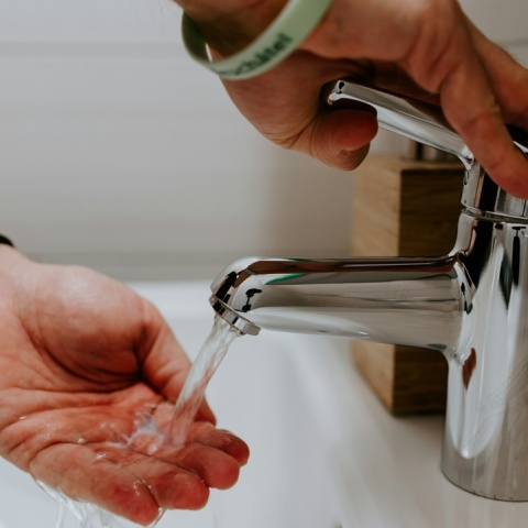 Άτομο πλένει τα χέρια του κάτω από τη βρύση