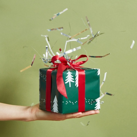 Δώρο με χριστουγεννιάτικο αμπαλάζ στο χέρια ατόμου