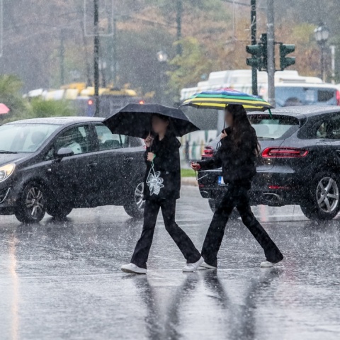 Πολίτες με ομπρέλες εν μέσω καταιγίδας στην Αττική