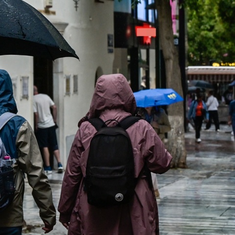 Πολίτες με ομπρέλα εν μέσω βροχής