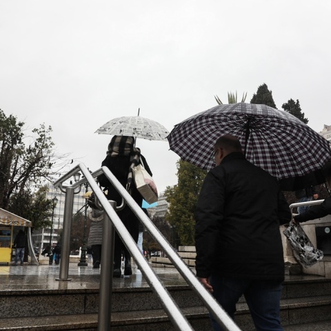 Πολίτες εν μέσω καταιγίδας έξω από τον σταθμό του μετρό στο Σύνταγμα