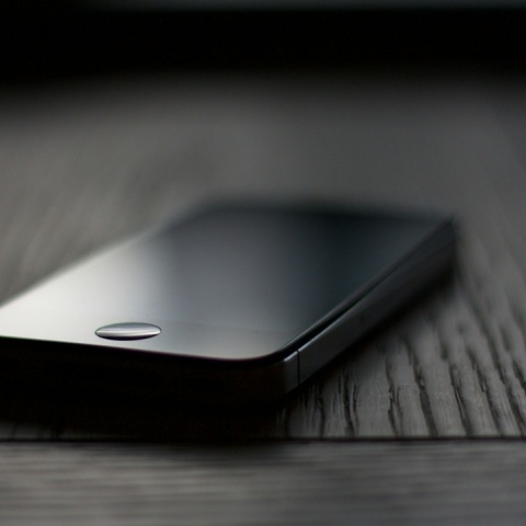 Κινητό ακουμπησμένο σε ένα ξύλο σε σκοτεινό σημείο