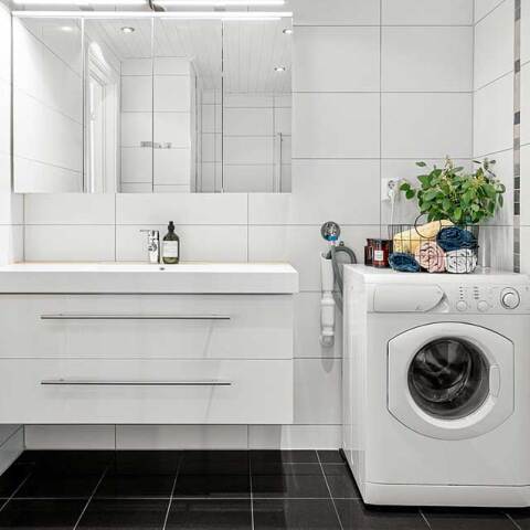 Μπάνιο με λευκά πλακάκια και λευκό πλυντήριο ρούχων