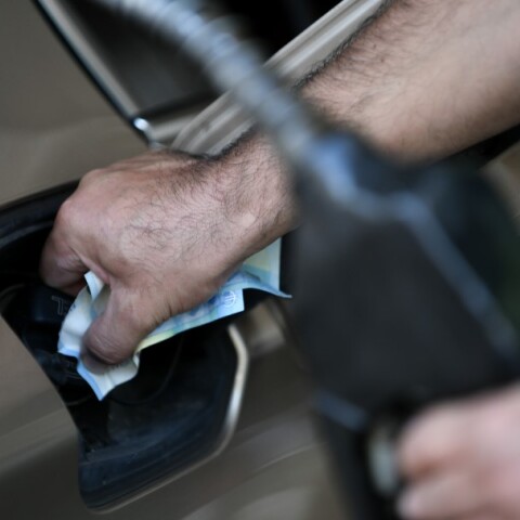 Υπάλληλος σε πρατήριο υγρών καυσίμων βάζει βενζίνη σε αυτοκίνητο