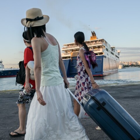 Επιβάτες στο λιμάνι του Πειραιά ετοιμάζονται να επιβιβαστούν σε πλοίο της γραμμής για νησιά του Αιγαίου