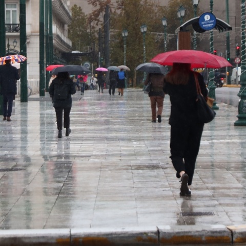 Άτομα με ομπρέλα εν μέσω καταιγίδας στην Αθήνα