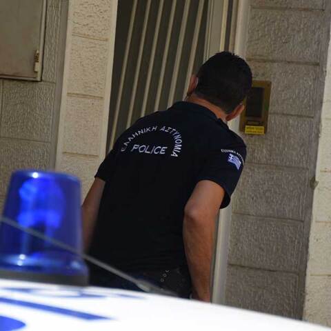 Αστυνομικός δίπλα σε περιπολικό