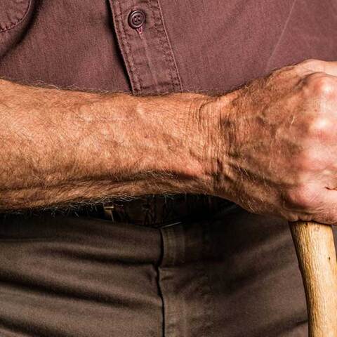 Ηλικιωμένος κρατά μαγκούρα στο χέρι