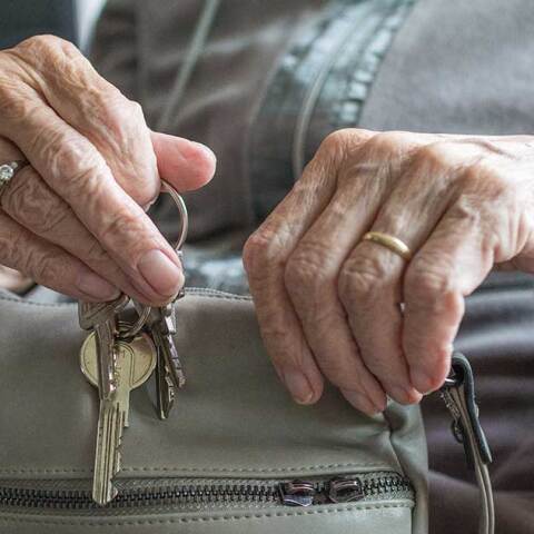 Ηλικιωμένη κρατά κλειδιά και τσάντα