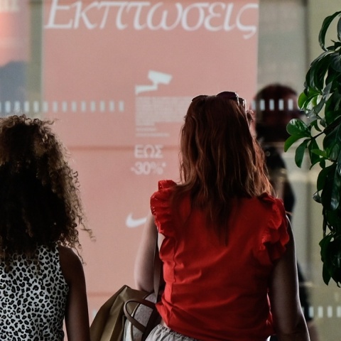 Γυναικες μπροστά από βιτρίνα κοιτούν προσφορές εκπτώσεων
