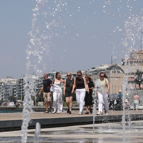 Πολίτες περπατούν πίσω από το σιντριβάνι στην παραλία της Θεσσαλονίκης
