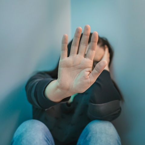 Γυναίκα που προτάσσει το χέρι της για να κρύψει το πρόσωπό της