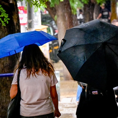 Πολίτες με ομπρέλες εν μέσω καταιγίδας