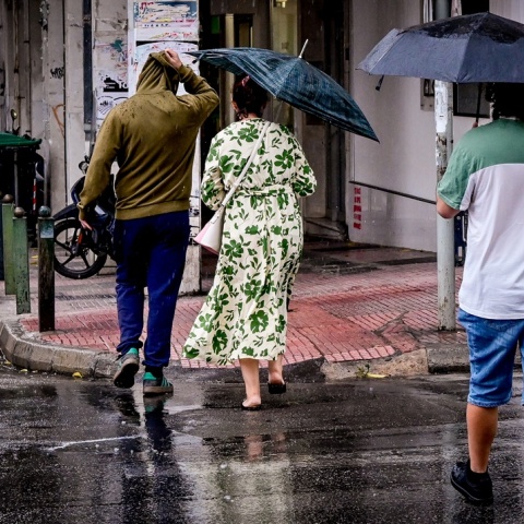 Πολίτες με ομπρέλα εν μέσω καταιγίδας