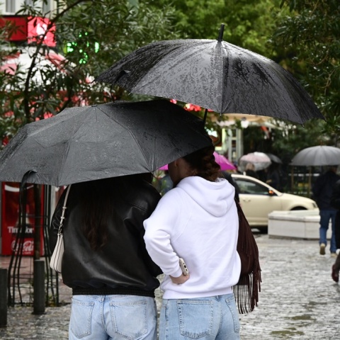 Άτομα με ομπρέλες εν μέσω βροχής