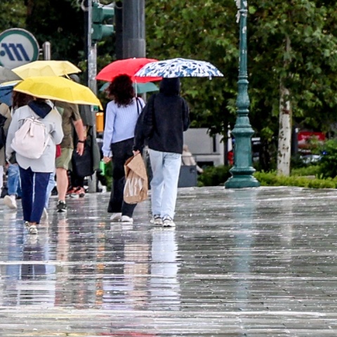 Πολίτες με ομπρέλες εν μέσω βροχής στο κέντρο της Αθήνας