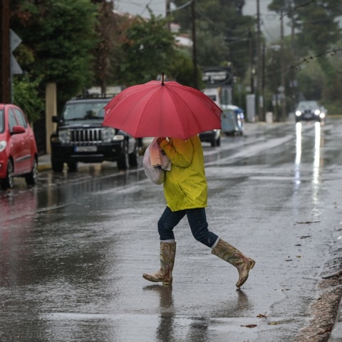 Γυναίκα με ομπρέλα εν μέσω καταιγίδας