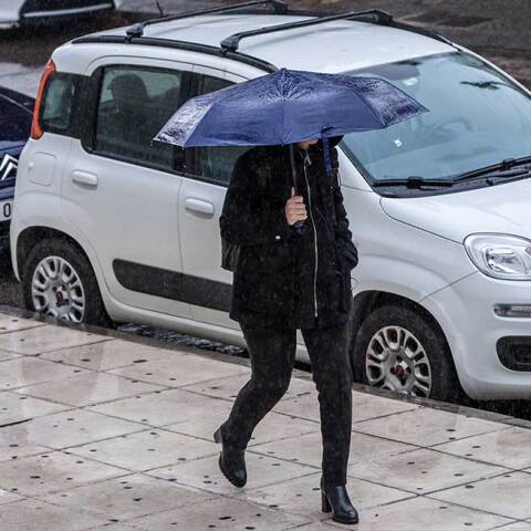 Γυναίκα με ομπρέλα εν μέσω κακοκαιρίας στην Αττική