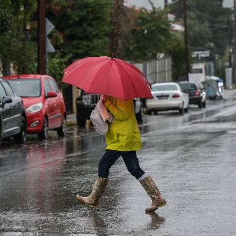 Γυναίκα υπό βροχή με ομπρέλα