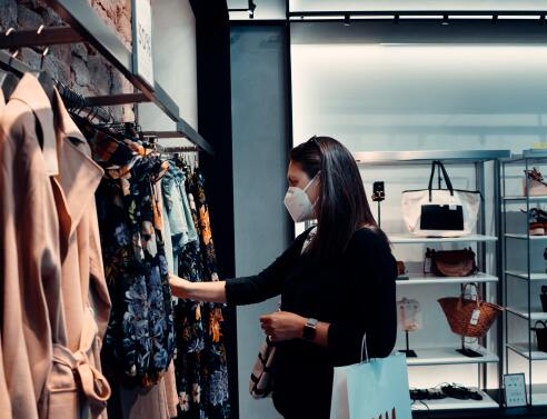 Γυναίκα κοιτάζει ρούχα σε κατάστημα ρούχων