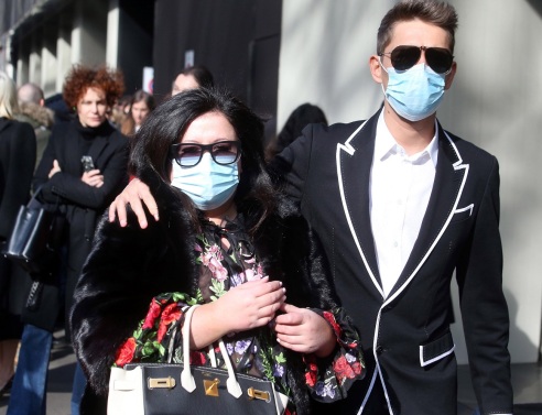 Άνδρας και γυναίκα με προστατευτικές μάσκες στην Εβδομάδα Μόδας του Μιλάνου